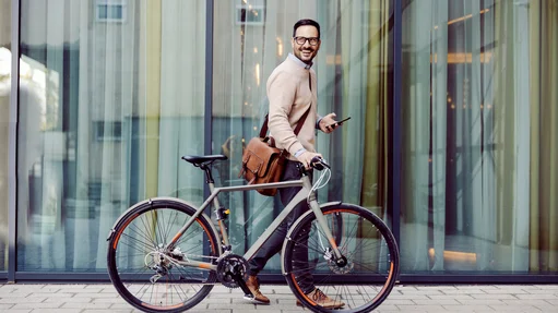Ein Mann im Anzug fährt Fahrrad und genießt die frische Luft in der Stadt.